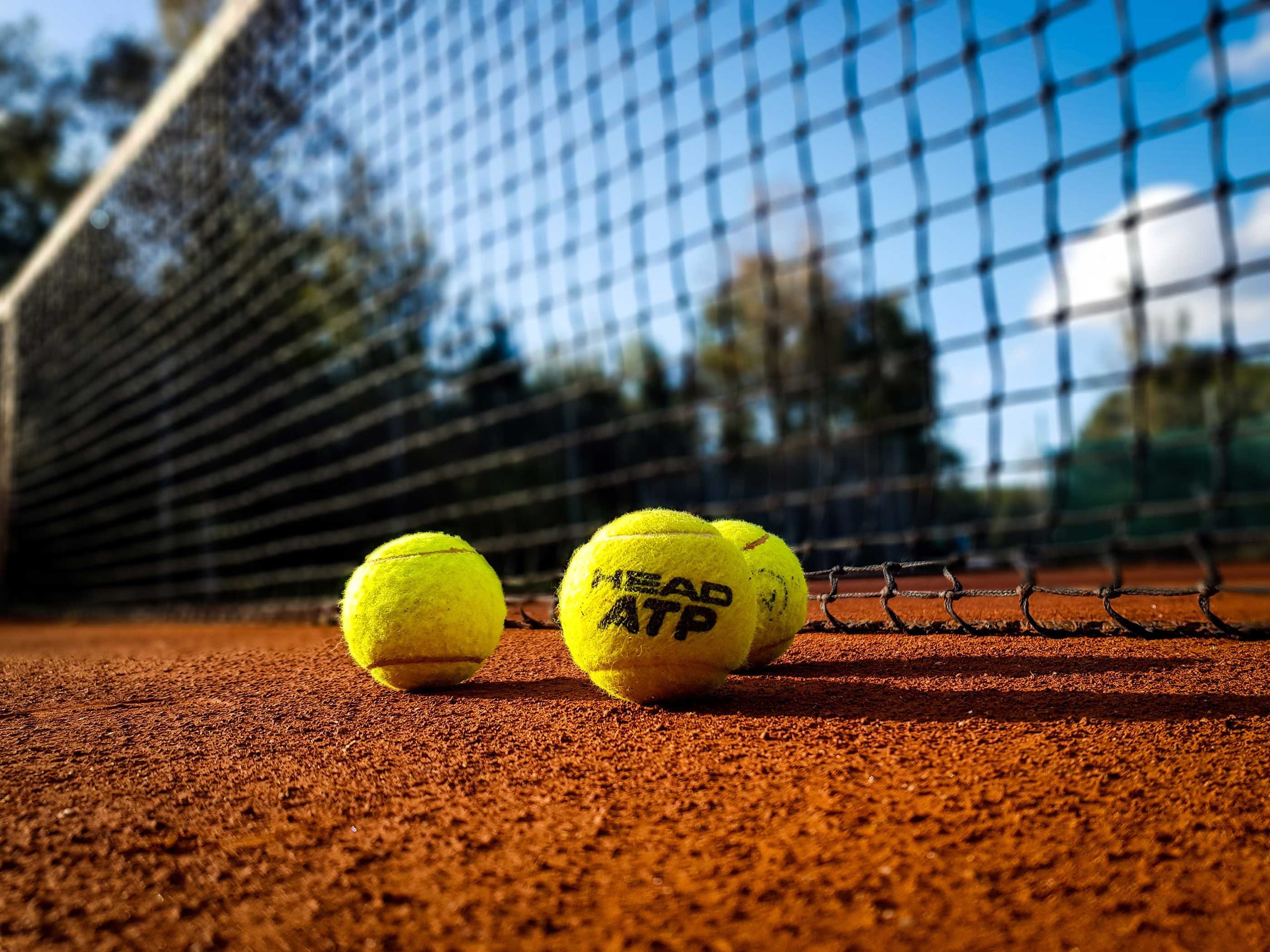 Tennis court with yellow tennisballs